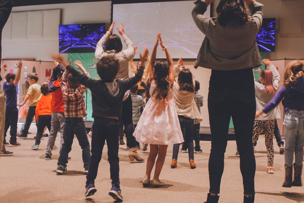 Kids in a worship group jumping and dancing together